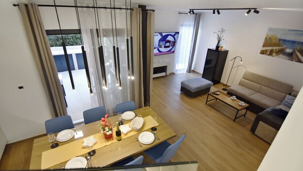 Un salon moderne comprenant un coin repas, un canapé, un téléviseur et une cheminée.