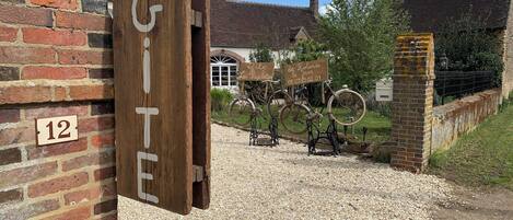 A rustic building with a wooden sign reading "GITE" and a number "12" on the wall.