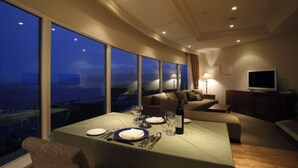 A dining area with a table set for two, large windows, a sofa, and a television in a modern living space. - HOTEL NEUSCHLOSS OTARU (Otaru)