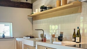 A modern kitchen with wooden cabinets, a white countertop, and a window providing natural light. - 5 Bedroom Agritourism property in Stockach (Stockach)