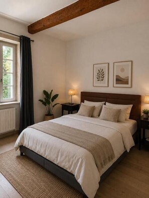 A bedroom with a large bed, a wooden ceiling beam, a window with curtains, a bedside table with a lamp, and two framed pictures on the wall.