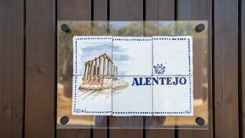 A sign with a building illustration and the word "ALENTEJO" on a wooden background.