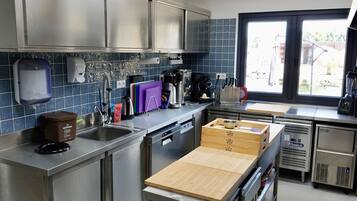 Una cocina moderna con electrodomésticos de acero inoxidable, lavavajillas y tabla de cortar de madera.