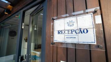 En skylt med texten ”Reception” sitter på en dörr av trä, med en glasruta.