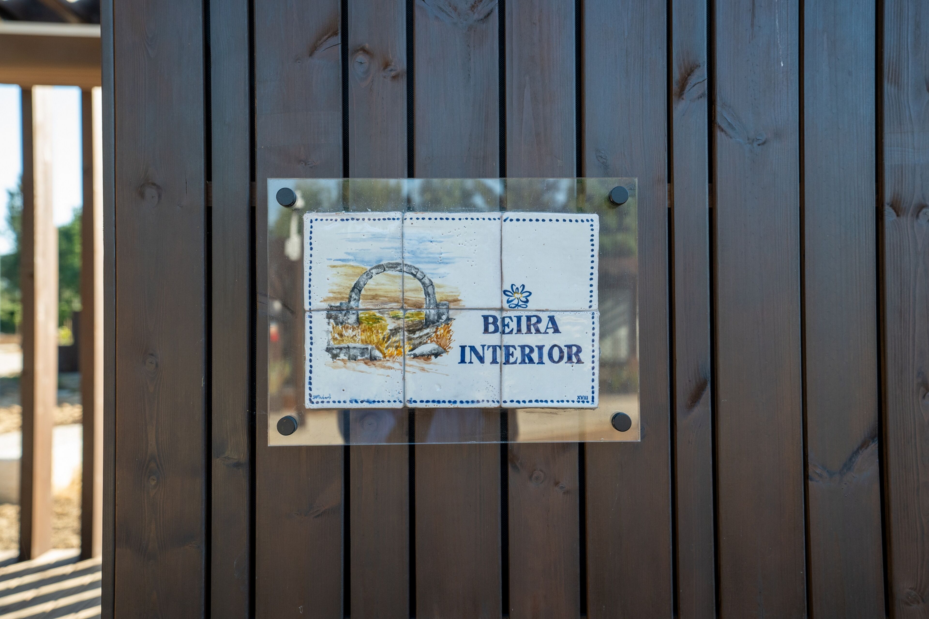Un letrero en una estructura de madera con el texto 'BEIRA INTERIOR'.