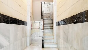Eine Marmortreppe mit Handlauf, die zu einer oberen Etage führt.