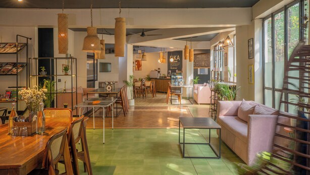 Um interior moderno com área de refeições, assentos e cozinha.