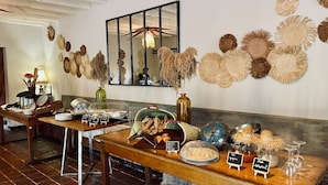 Mesa de buffet con diversos alimentos y un espejo en la pared.