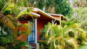 Edificio de una planta con porche, rodeado de exuberante vegetación tropical.