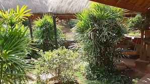 Una estructura con techo de paja rodeada de exuberante vegetación.