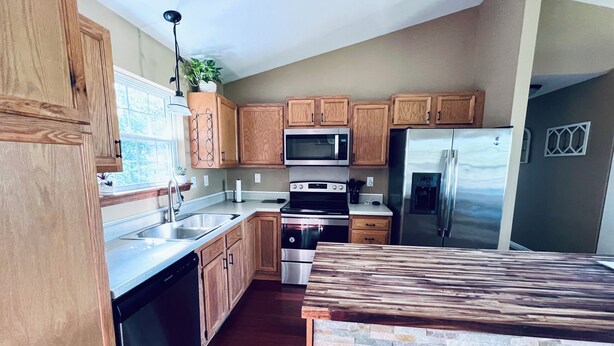 A modern kitchen with wooden cabinets, stainless steel appliances, and a stone backsplash. - NEW Spacious Home Minutes From Oneida Lake & Fall Festivities!  (Brewerton)