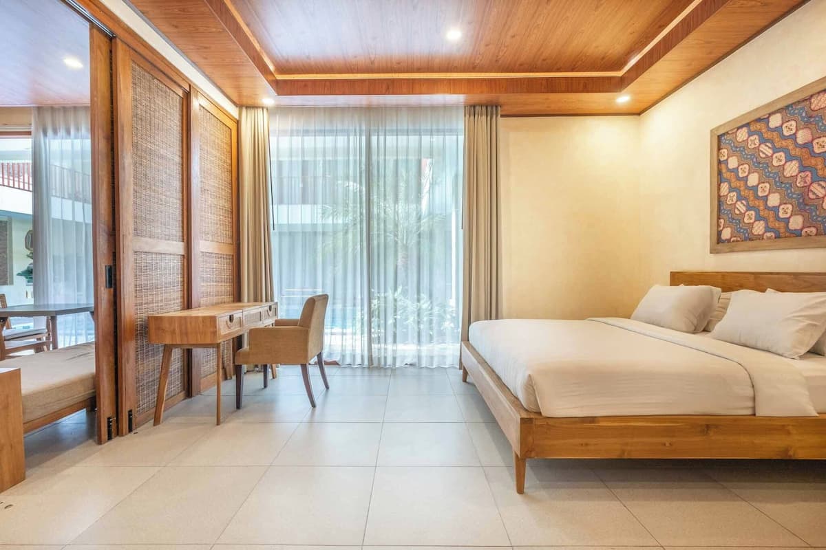 Una habitación de hotel con una cama de madera, un escritorio y una silla.
