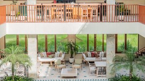 Una casa a due piani con un balcone, una piscina e un'area pranzo.