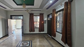 A hallway with a ceiling fan, patterned floor tiles, and a view of the outside. - Mirpur 3-bed House Sleeps 6 (Mirpur)