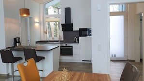 Una cucina moderna con forno integrato, microonde e un'ampia finestra.