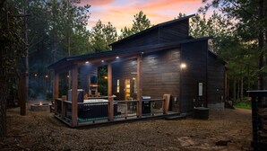 A rustic cabin with a covered porch, stone fire pit, and outdoor seating. - Office Desk, Deck, Hot Tub, Fire Pit, Pets, Lost in Nature (Broken Bow)