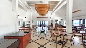 A spacious dining area with high ceilings, large windows, and a central island.