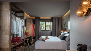 A bedroom with a bed, a desk, and a wardrobe.