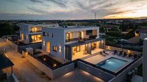 A modern two-story house with a rooftop pool, outdoor seating area, and a well-lit patio. - Villa Roko Nin ZadarVillas (Nin)