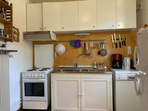 A compact kitchen with a stove, oven, sink, and refrigerator.
