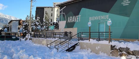 A snow-covered area with a building featuring a large sign that reads "ARAVET" and "BIENVENUE."