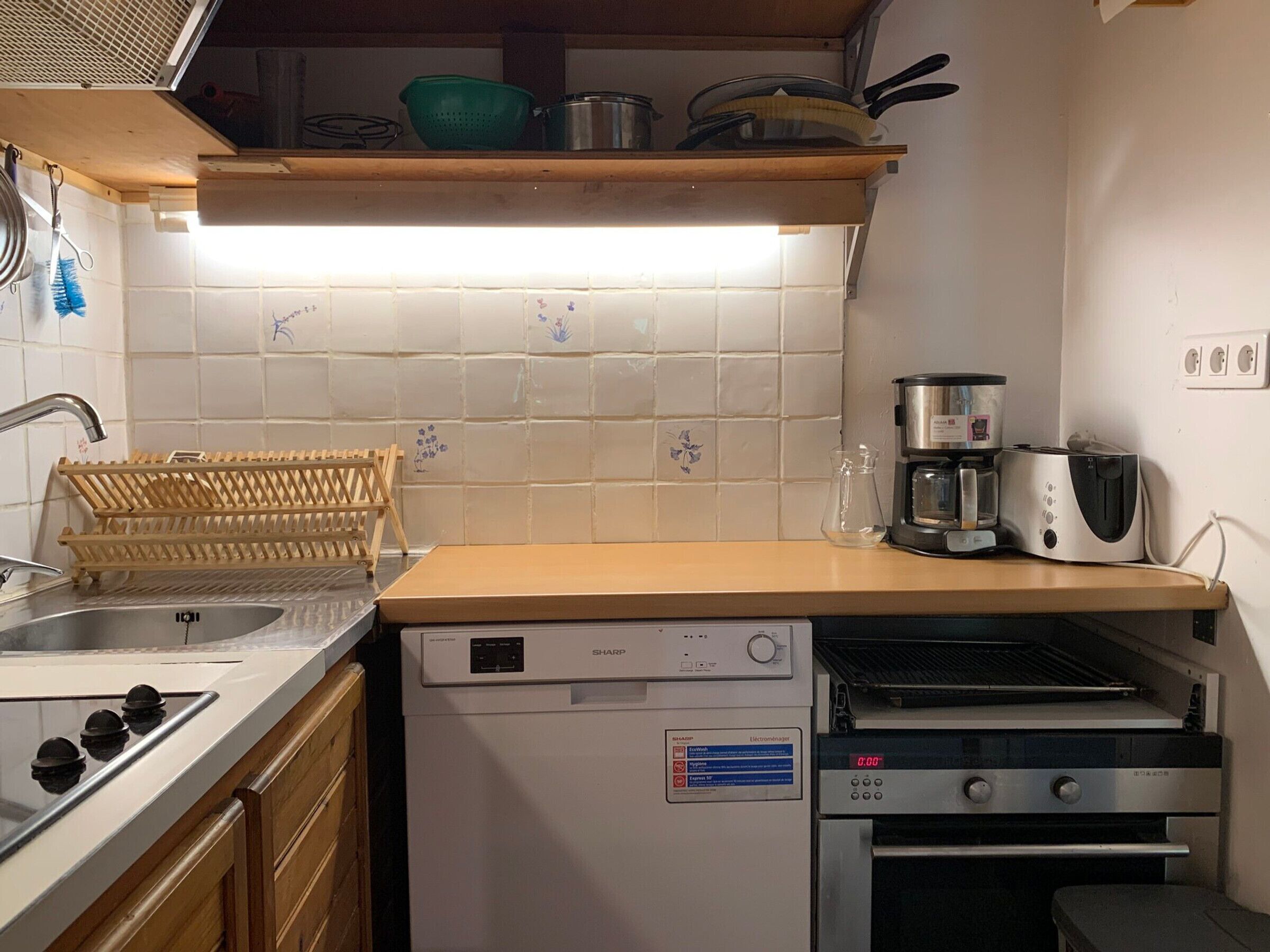 A compact kitchen with a dishwasher, a toaster, and a microwave.