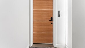 Une porte en bois avec une poignée noire et une plaque indiquant le numéro de la porte.