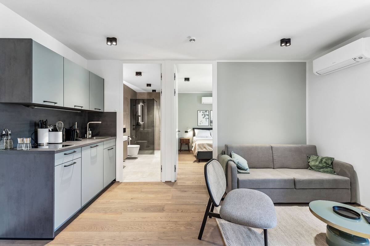 A modern apartment with a kitchen, dining area, and living room.