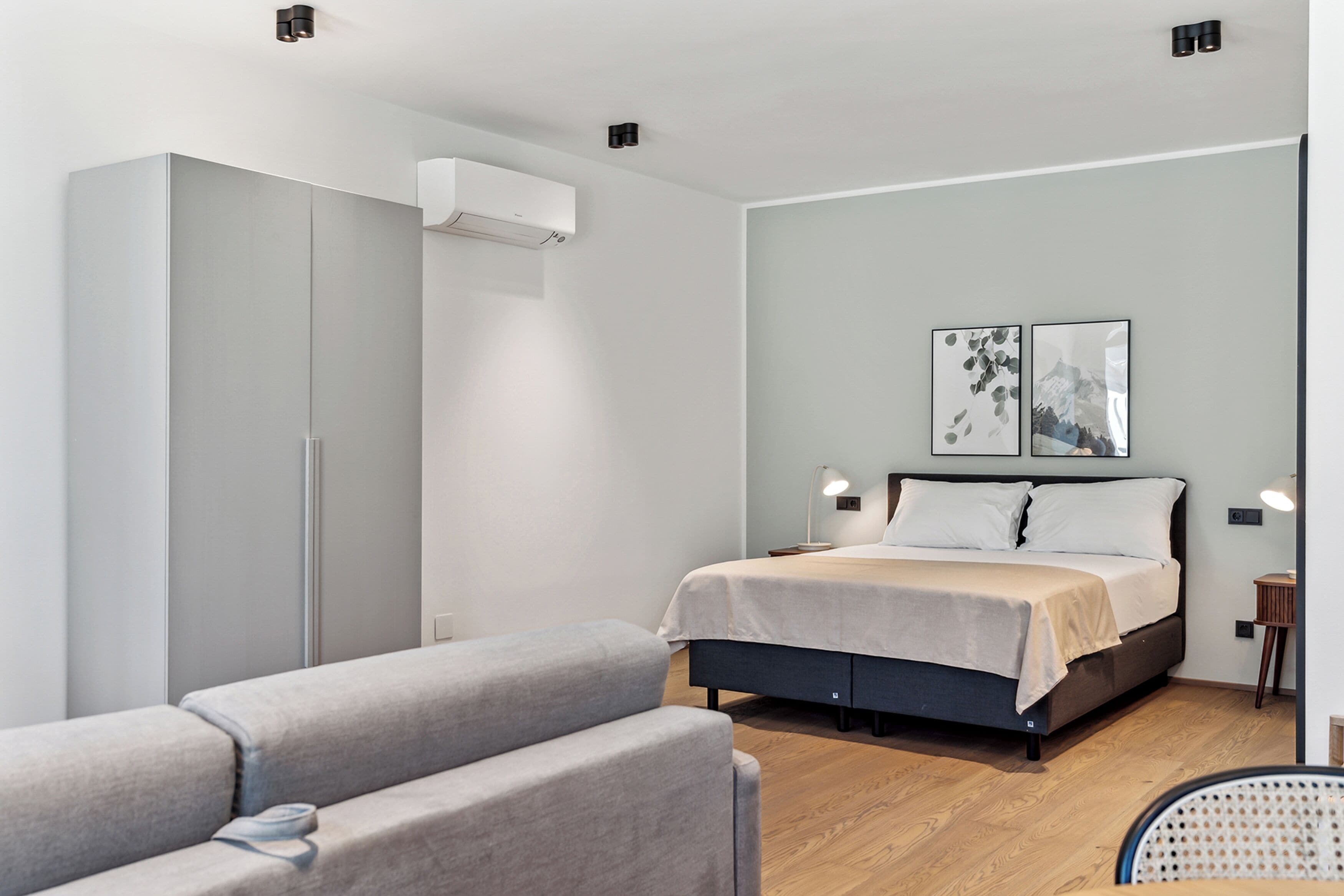 Ein modernes Schlafzimmer mit Bett, Kleiderschrank, Schreibtisch und Stuhl.