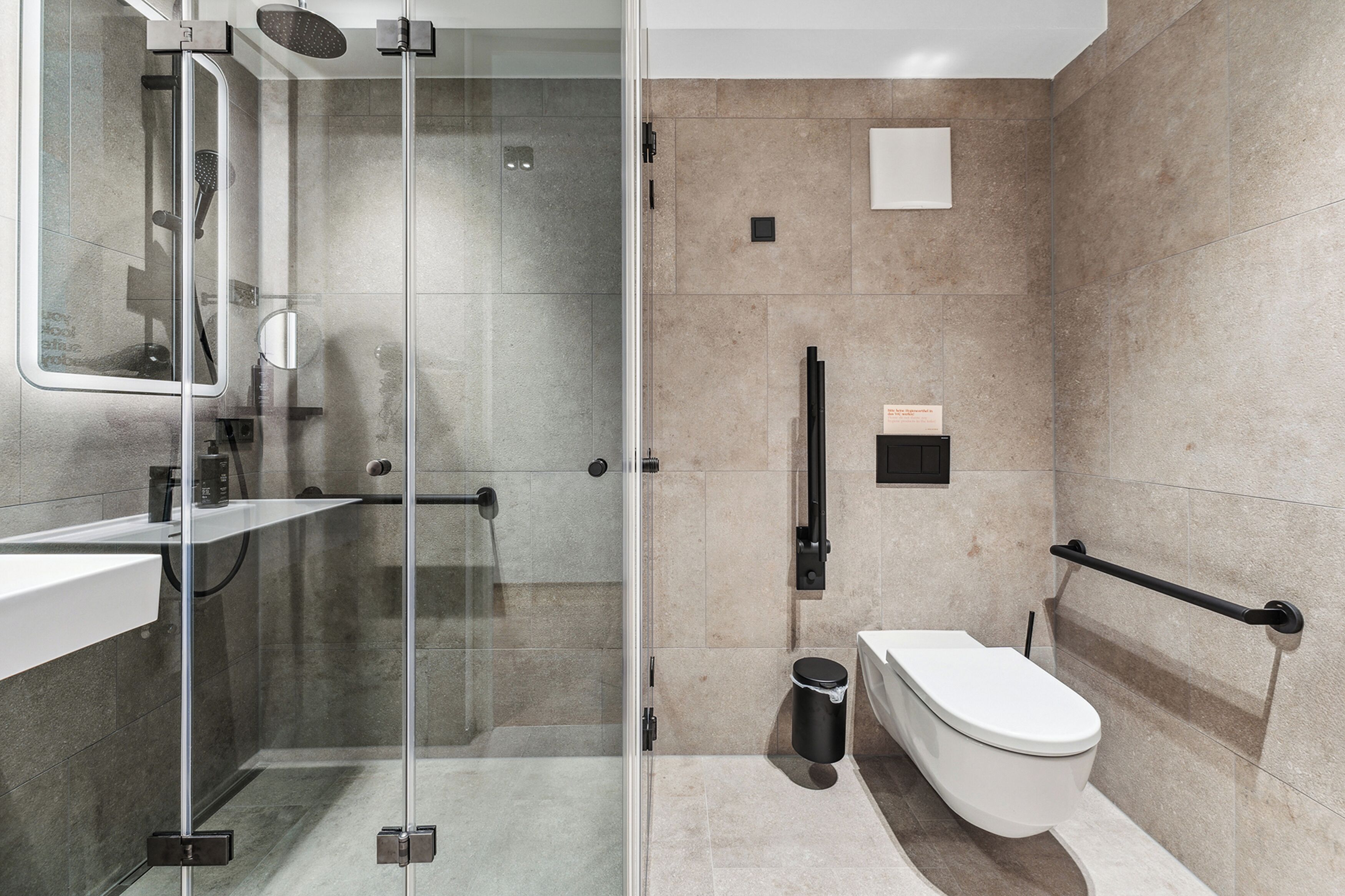 Une salle de bain moderne avec une douche à parois de verre, des toilettes et un lavabo.