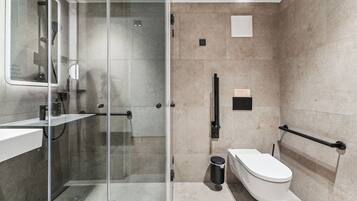 Un baño moderno con ducha envuelta en vidrio, inodoro y lavamanos.