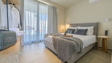 Una habitación de hotel ordenada con cama, mesita de noche y ventana con cortinas.