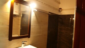 A bathroom with a white sink, a mirror, and a shower area. - Paradeisos Studio With Garden View (Zagora-Mouresi)