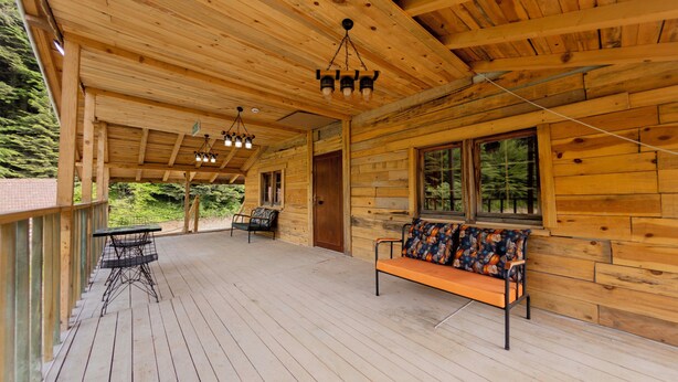 A wooden cabin with a porch, a bench, and a table. - Abant İlbey Dağ Evi (Bolu)