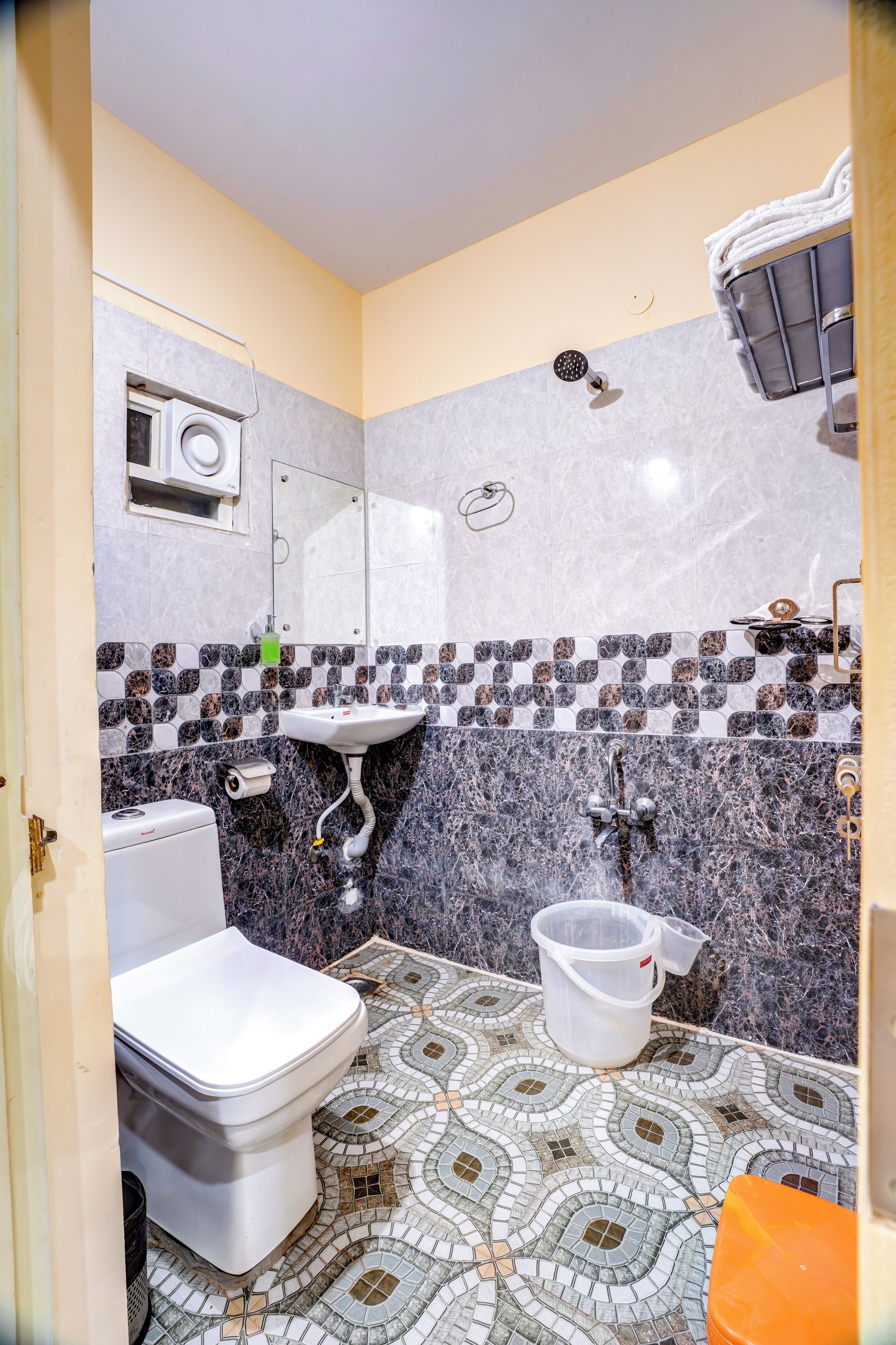 Une salle de bain comprenant des toilettes, un lavabo et un espace douche.