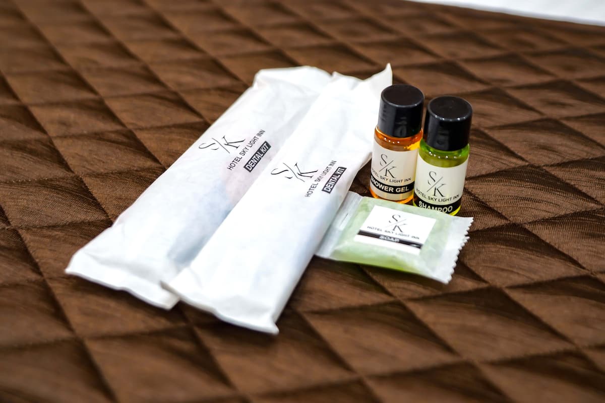 A toiletry set including a towel, shampoo, conditioner, and soap on a textured surface.