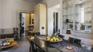 Eine moderne Küche mit einer zentralen Kochinsel, einem Essbereich mit einer Couch und einem Glaskasten für Küchenutensilien.