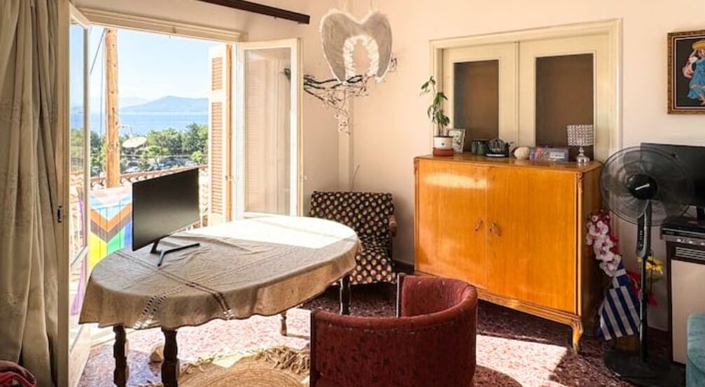 Una habitación con cama, una mesa, un armario y vistas al exterior.