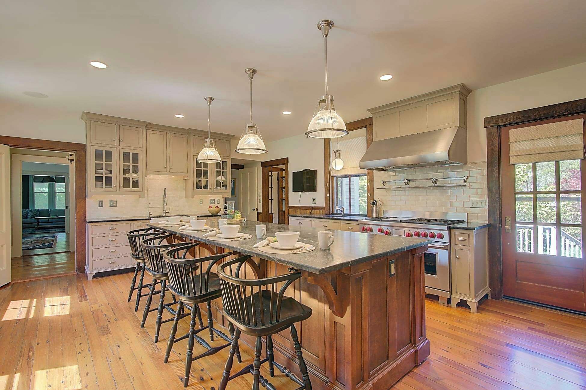 A spacious kitchen with a large island, bar stools, and modern appliances.