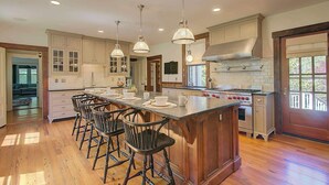 A spacious kitchen with a large island, bar stools, and modern appliances. - Short Drive to Gray's Beach! (Yarmouth)