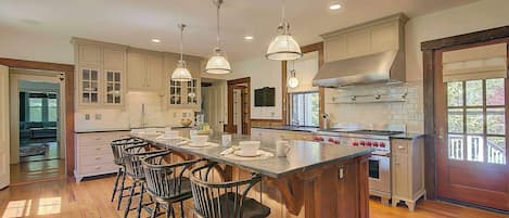 A spacious kitchen with a large island, bar stools, and modern appliances.