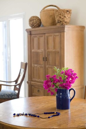 A wooden cabinet with a vase of flowers on a wooden table.
