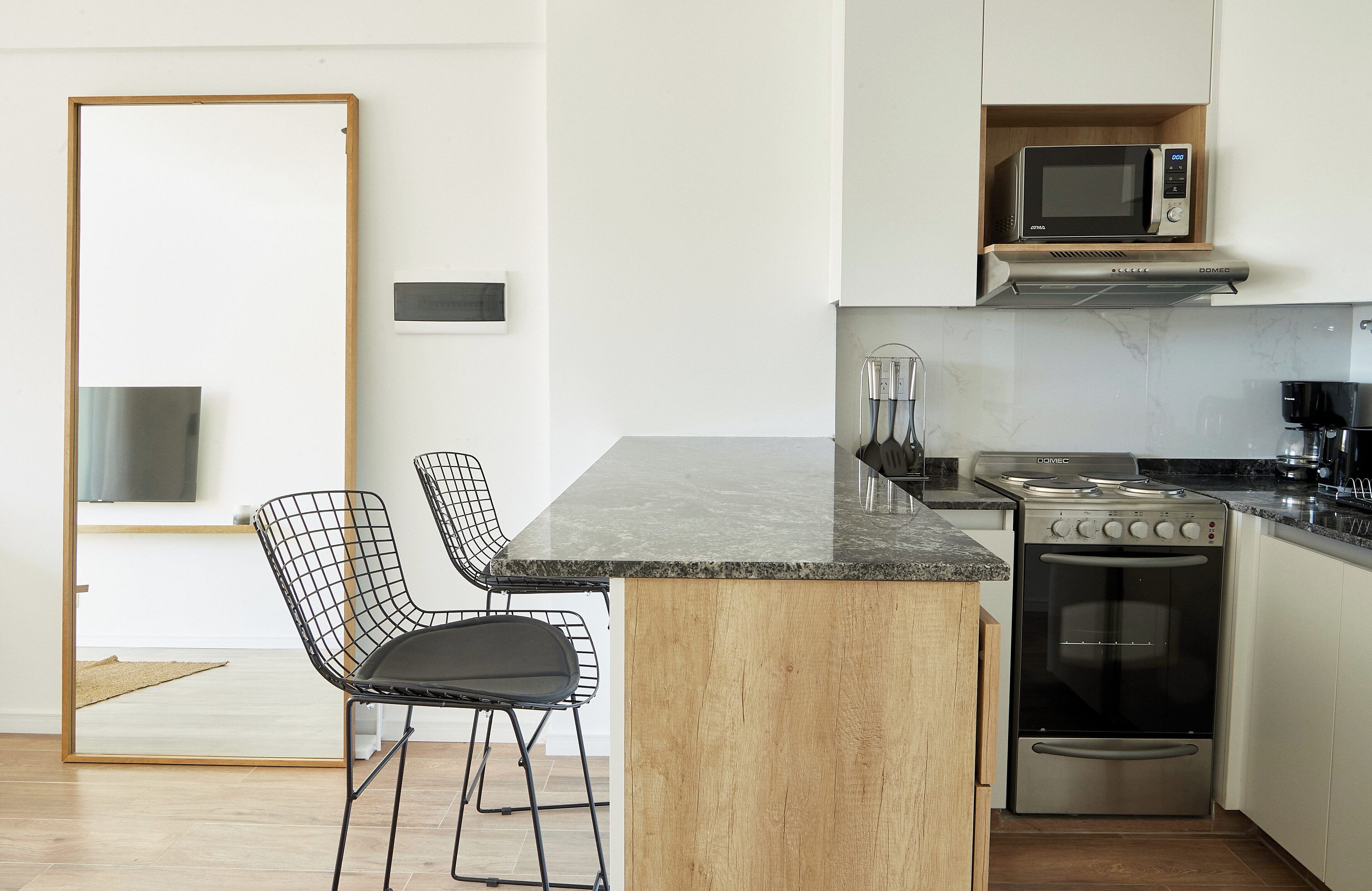 Una cocina moderna con una isla central, horno integrado y microondas.