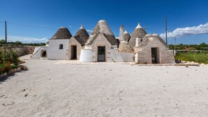 A series of stone-roofed buildings with a gravel driveway. - 4003 Brunaldi Trulli by Perle di Puglia (Martina Franca)