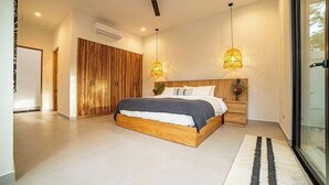Ein modernes Schlafzimmer mit einem hölzernen Bettgestell, zwei Nachttischen, einem Deckenventilator und Pendelleuchten.