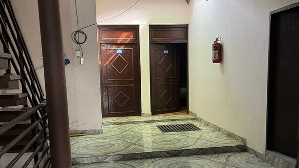 A hallway with two doors, one marked 106 and the other 105, leading to a staircase. - Hotel Aryavart (Meerut)