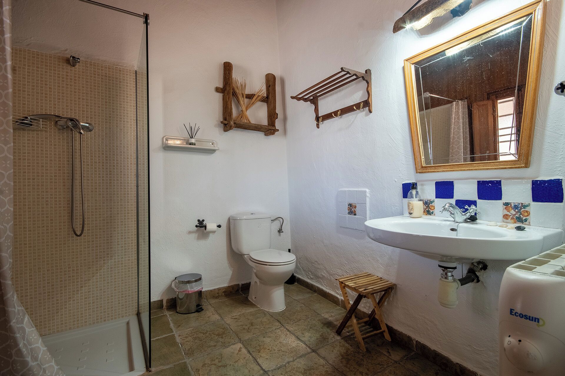 Une salle de bain équipée d’une douche, de toilettes, d’un lavabo et d’un miroir.