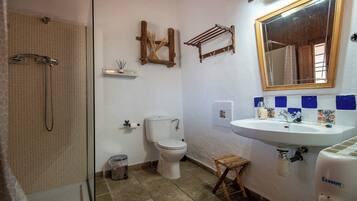 Une salle de bain équipée d’une douche, de toilettes, d’un lavabo et d’un miroir.
