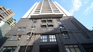 A tall, modern building with multiple floors, large windows, and balconies. - Modern 1-bedroom apartment by Sweet Home (Yerevan)