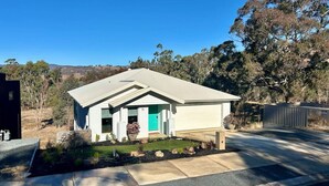 A modern single-story house with a sloped roof, a front porch, and a small garden area. - House on the hill | Kangaroo lookout (Wodonga)
